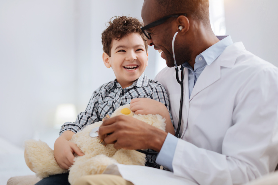 Afro american male doctor diagnosing plush bear